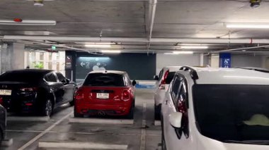 Birbirine yakın arabalarla dolu hareketli bir otopark..