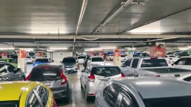 Birbirine yakın arabalarla dolu hareketli bir otopark..