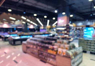 Birçok rafı ve ekranı olan bir marketin bulanık görüntüsü.