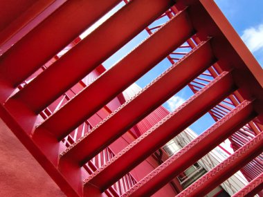 Büyük kırmızı bir duvara tırmanan bir merdiven seti..