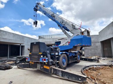 Şu anda yapım aşamasında olan bir binanın önüne büyük bir vinç park edilmiş..
