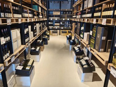 Çok sayıda şarap şişesi ve kutu bulunan geniş bir mağaza..