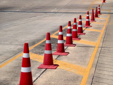 Bir sıra kırmızı ve beyaz trafik konisi bir yol tarafından yerleştirilir..