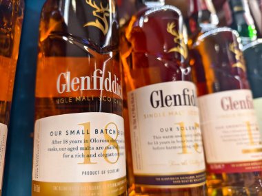 PHUKET, THAILAND - 8 Mart 2025: Bir süpermarkette raftaki viski şişeleri The Glenfiddich.