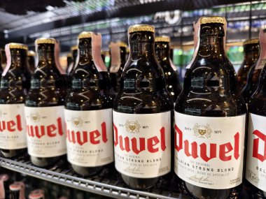 PHUKET, THAILAND - 8 Mart 2025: Bir rafta düzgünce dizilmiş Duvel biraları.