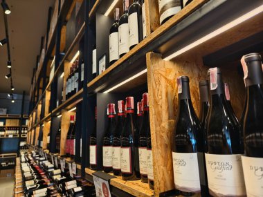 PHUKET, THAILAND - 8 Mart 2025: Çok sayıda şarap şişesi ve kutu içeren bir mağaza.