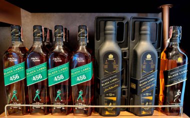 PHUKET, THAILAND - 8 Mart 2025: Bir süpermarketteki rafta Johnnie Walker 'ın viski şişeleri.