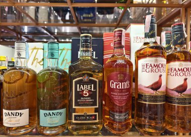 PHUKET, THAILAND - 8 Mart 2025: sayısız çeşitli alkol şişeleriyle dolu bir perakende mağazası.