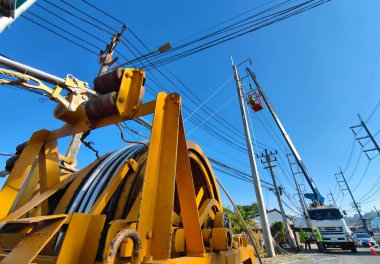 Yol boyunca yeni direklere yüksek gerilimli elektrik kabloları kurulumu.