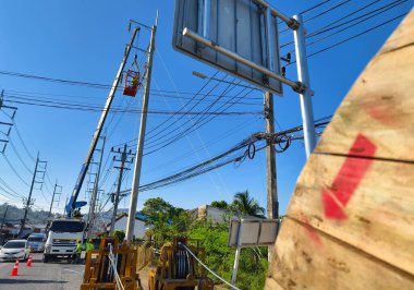 Yol boyunca yeni direklere yüksek gerilimli elektrik kabloları kurulumu.