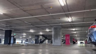 Modern bir elektrikli araç, çağdaş bir otoparkın içine park ediyor..