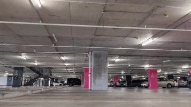 Modern bir elektrikli araç, çağdaş bir otoparkın içine park ediyor..