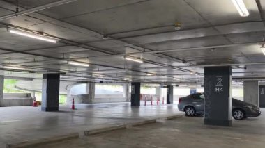 Geniş ve modern bir otopark. Temiz hatları ve bol ışıklandırması var. 