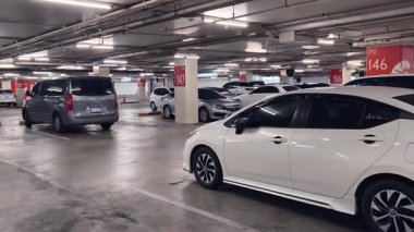 Birbirine yakın arabalarla dolu hareketli bir otopark..