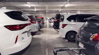 Birbirine yakın arabalarla dolu hareketli bir otopark..