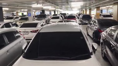Birbirine yakın arabalarla dolu hareketli bir otopark..