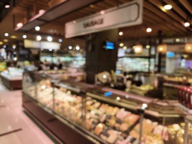 Birçok rafı ve ekranı olan bir marketin bulanık görüntüsü.