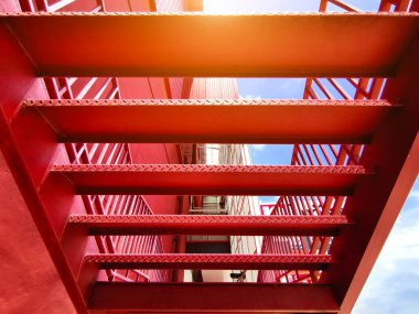 Büyük kırmızı bir duvara tırmanan bir merdiven seti..