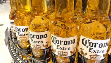 PHUKET, THAILAND - 8 Mart 2025: Corona biraları düzgünce bir rafa dizildi.