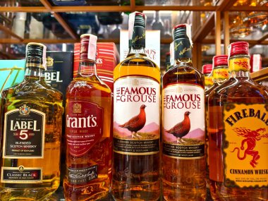 PHUKET, THAILAND - 8 Mart 2025: sayısız çeşitli alkol şişeleriyle dolu bir perakende mağazası.