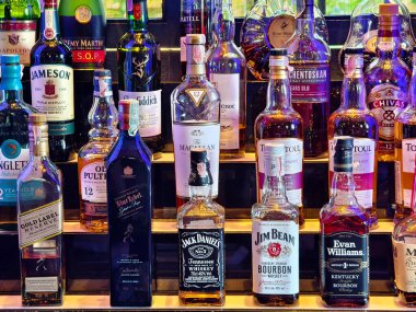 PHUKET, THAILAND - 8 Mart 2025: Bir bar rafında düzgünce düzenlenmiş bir sürü şarap şişesi.