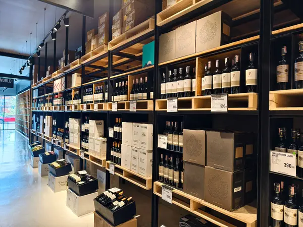 Çok sayıda şarap şişesi ve kutu bulunan geniş bir mağaza..