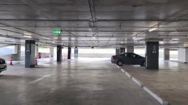 Geniş ve modern bir otopark. Temiz hatları ve bol ışıklandırması var. 