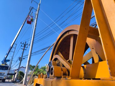 Yol boyunca yeni direklere yüksek gerilimli elektrik kabloları kurulumu.