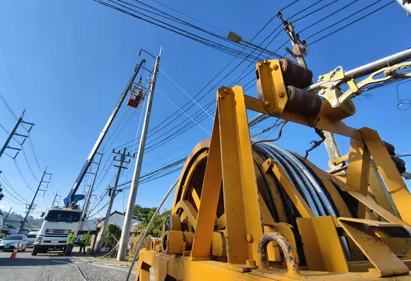 Yol boyunca yeni direklere yüksek gerilimli elektrik kabloları kurulumu.