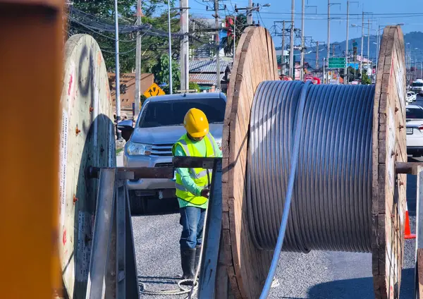 Yol boyunca yeni direklere yüksek gerilimli elektrik kabloları kurulumu.