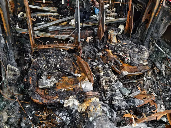 Yıkıcı bir yangından sonra yanan bir aracın iç kısmının kalıntıları..