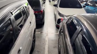 Birbirine yakın arabalarla dolu hareketli bir otopark..