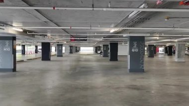 Geniş ve modern bir otopark. Temiz hatları ve bol ışıklandırması var. 