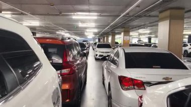 Birbirine yakın arabalarla dolu hareketli bir otopark..