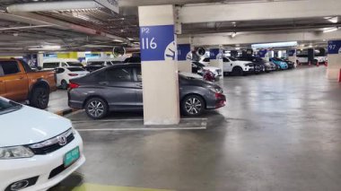 Düzenli olarak dizilmiş çeşitli arabaların sergilendiği modern bir otopark.