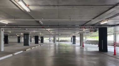 Geniş ve modern bir otopark. Temiz hatları ve bol ışıklandırması var. 
