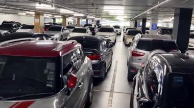 Birbirine yakın arabalarla dolu hareketli bir otopark..
