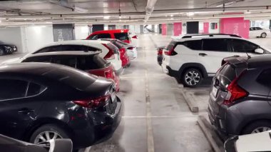 Birbirine yakın arabalarla dolu hareketli bir otopark..