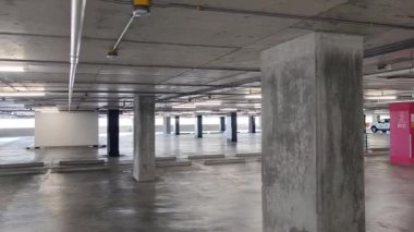 Geniş ve modern bir otopark. Temiz hatları ve bol ışıklandırması var. 