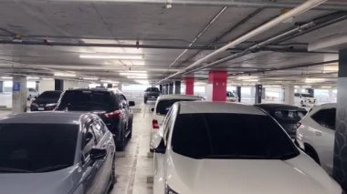 Birbirine yakın arabalarla dolu hareketli bir otopark..