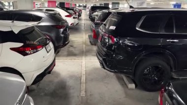 Birbirine yakın arabalarla dolu hareketli bir otopark..