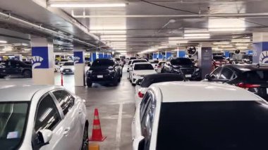 Birbirine yakın arabalarla dolu hareketli bir otopark..