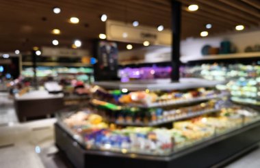 Birçok rafı ve ekranı olan bir marketin bulanık görüntüsü.