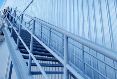 Büyük mavi bir duvara tırmanan bir merdiven seti..