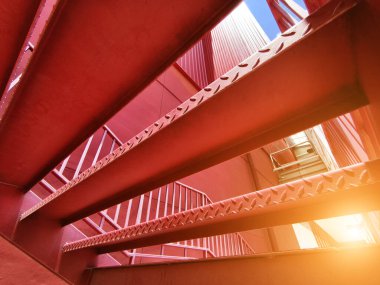 Büyük kırmızı bir duvara tırmanan bir merdiven seti..