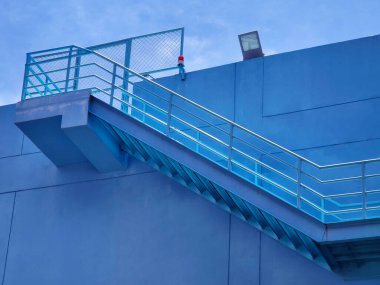 Büyük mavi bir duvara tırmanan bir merdiven seti..