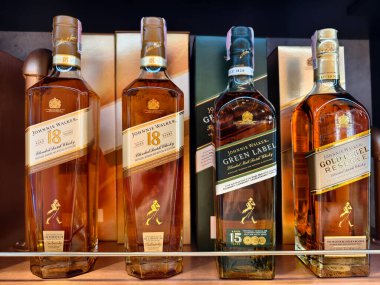 PHUKET, THAILAND - 8 Mart 2025: Bir süpermarketteki rafta Johnnie Walker 'ın viski şişeleri.