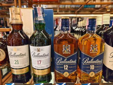 PHUKET, THAILAND - 8 Mart 2025: sayısız çeşitli alkol şişeleriyle dolu bir perakende mağazası.