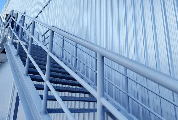 Büyük mavi bir duvara tırmanan bir merdiven seti..