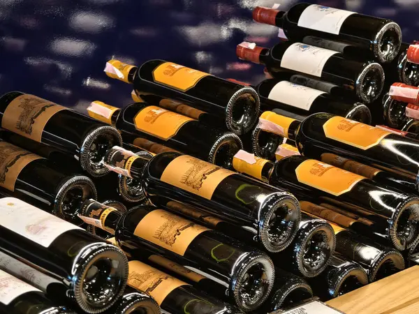 Bir mağaza rafında düzgünce düzenlenmiş bir sürü şarap şişesi..